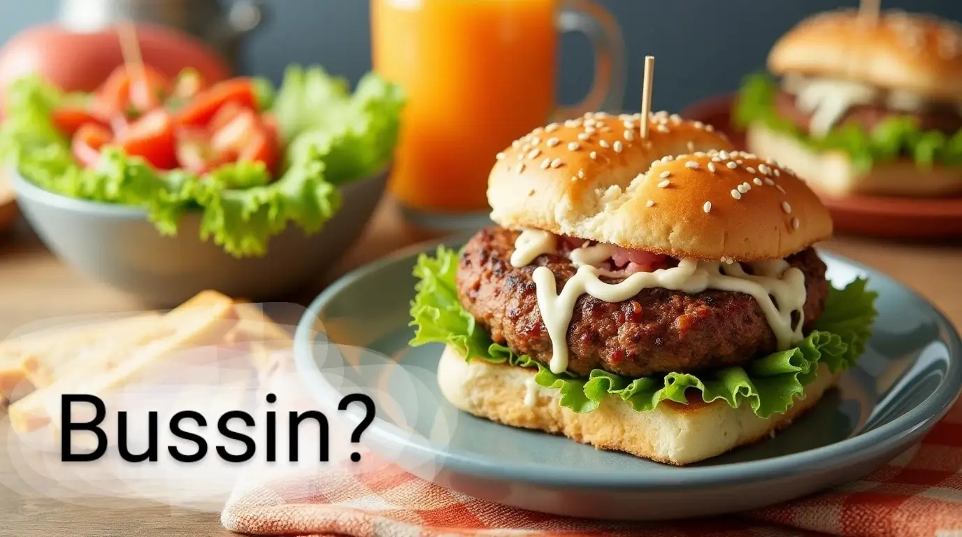 A juicy cheeseburger with lettuce and mayo on a sesame bun, served on a plate with fresh salad and orange juice in the background — a true bussin meal.